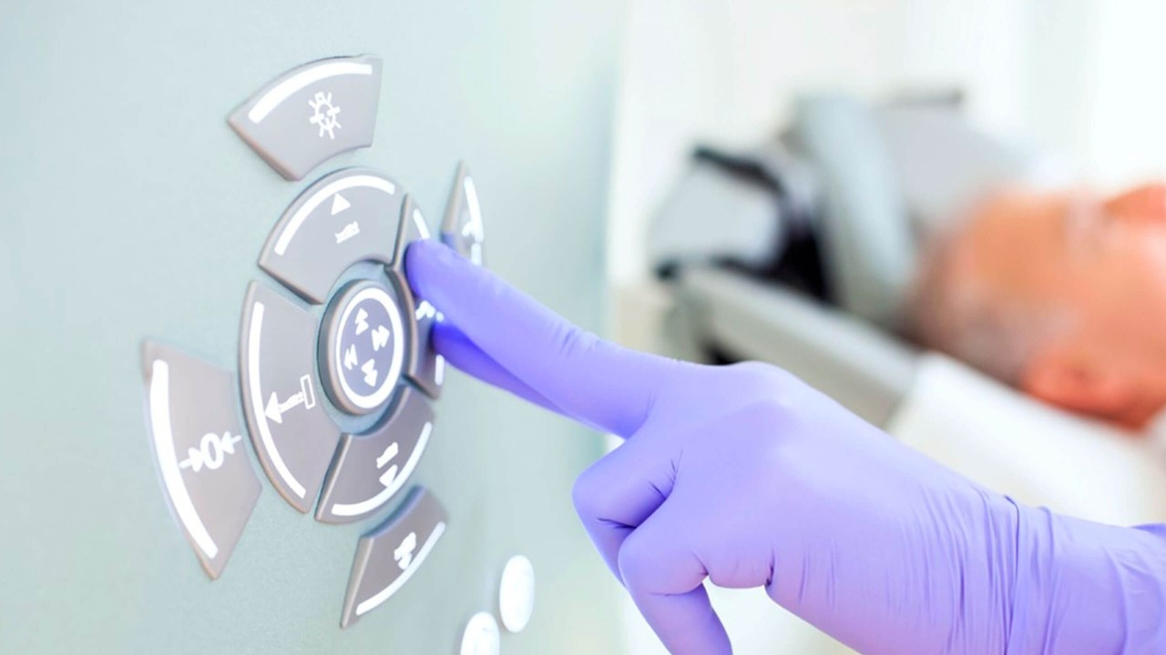 Kuvituskuva: Lääkärin käsi kumihanskassa painaa magneettikuvauslaitteen nappia.