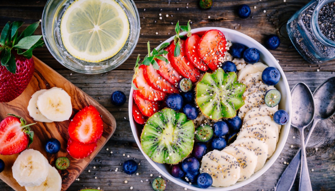 Healthy breakfast bowl: oatmeal with banana, kiwi, strawberry, blueberries and chia seeds